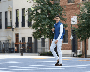 Man in The Swenson Vest: Andover, stepping on a city street, showcasing its sleek design and flexibility, ideal for maintaining warmth and mobility.