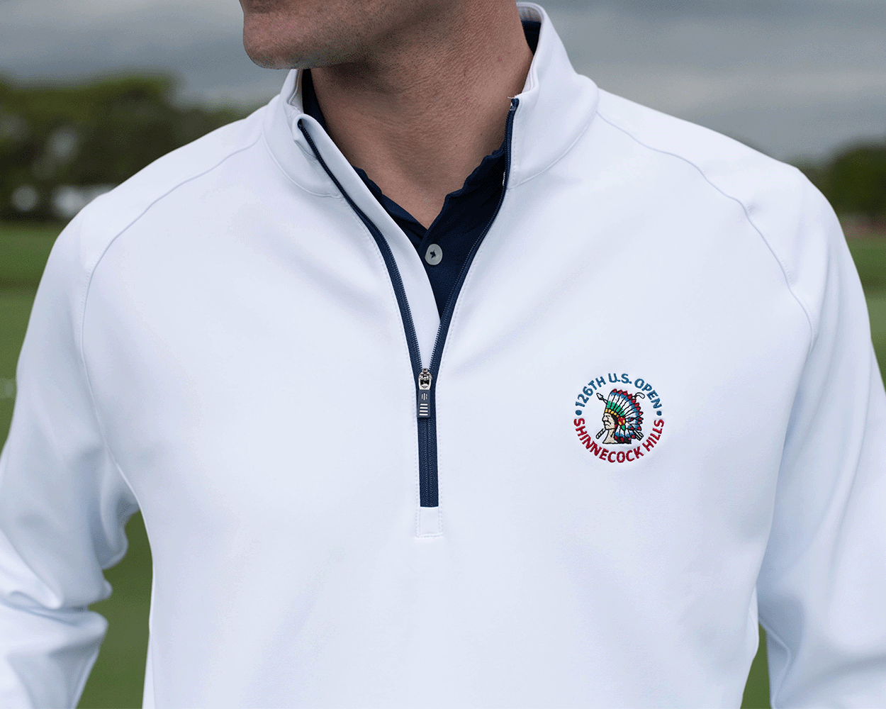 Person wearing the 2026 U.S. Open Rodgers Pullover: White, featuring a quarter-zip design and embroidered logo, ideal for golfing and casual gatherings.